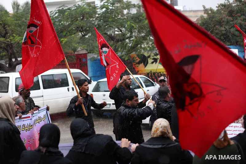 Supporters of Democratic Front for the Liberation of Palestine (DFLP) hold flags and portraits of Palestinian prisoners held in Israeli jails during a rally calling for their release, in Gaza city on Dec. 13, 2012. Photo...