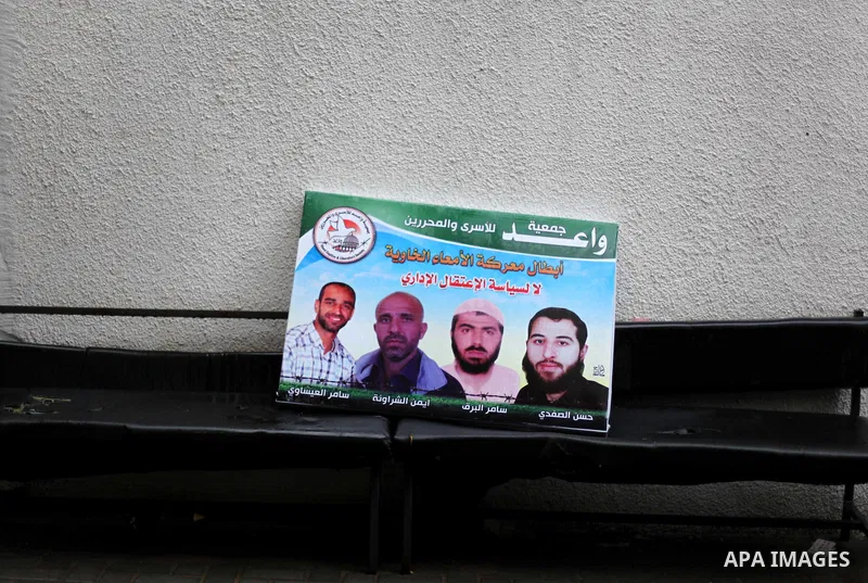 Supporters of Democratic Front for the Liberation of Palestine (DFLP) hold flags and portraits of Palestinian prisoners held in Israeli jails during a rally calling for their release, in Gaza city on Dec. 13, 2012. Photo...