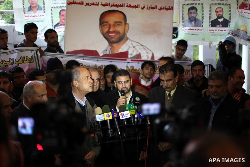 The spokesman of Hamas, Sami Abu Zuhri during a press conference in Gaza city on Dec. 13, 2012. Supporters of Democratic Front for the Liberation of Palestine (DFLP) hold flags and portraits of Palestinian prisoners held...