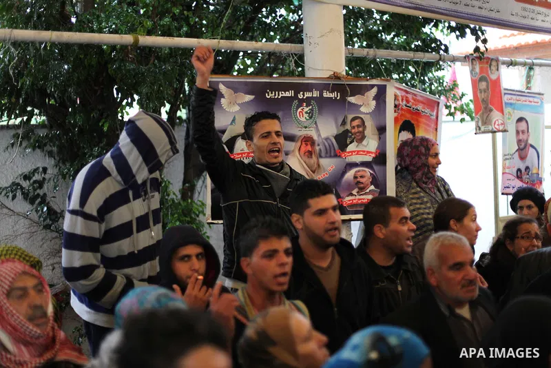 Supporters of Democratic Front for the Liberation of Palestine (DFLP) hold flags and portraits of Palestinian prisoners held in Israeli jails during a rally calling for their release, in Gaza city on Dec. 13, 2012. Photo...
