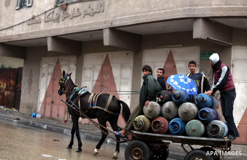Palestinians cross a flooded street in al-Shatee refugee camp in Gaza City on Dec. 13, 2012. Palestinian refugees in Gaza camps need more support to reconstruct Gaza, promote economic recovery and address the long-term d...