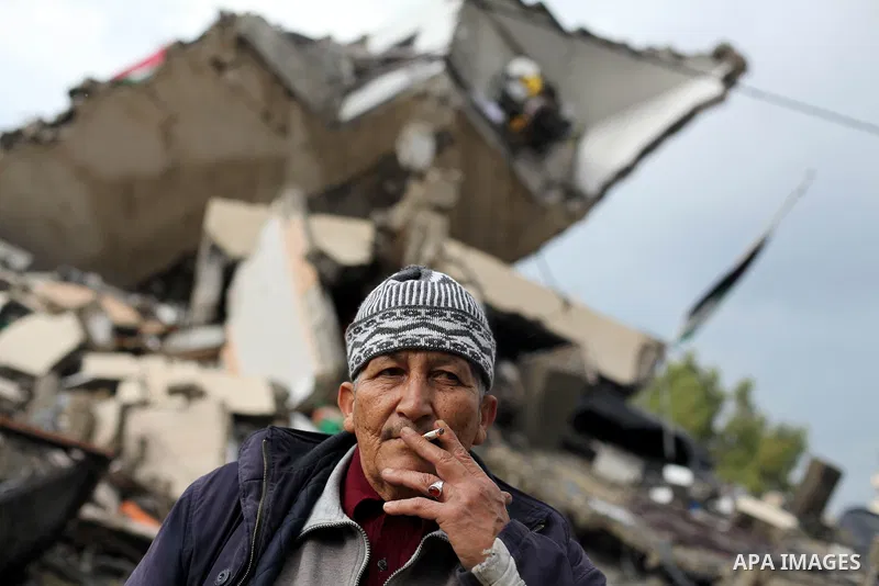 A Palestinian man stands in front of rubbles while Qatari ambassador Mohammed al-Imadi visits bombed areas after the launching ceremony of Qatari grant projects in Gaza city on 13 Dec, 2012. The emir of Qatar Sheikh Hama...