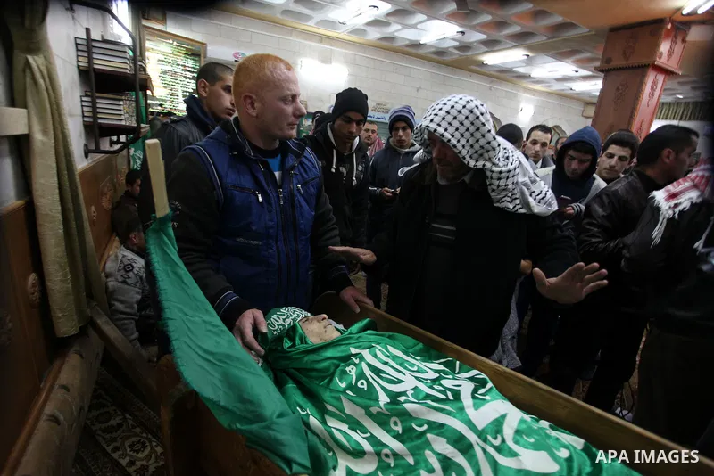 Relatives of Palestinian teenager Mohammed Ziad Salaymeh mourn next to his dead body during the funeral in the West Bank city of Hebron, 13 December 2012. Israeli border police in the divided West Bank city of Hebron on...