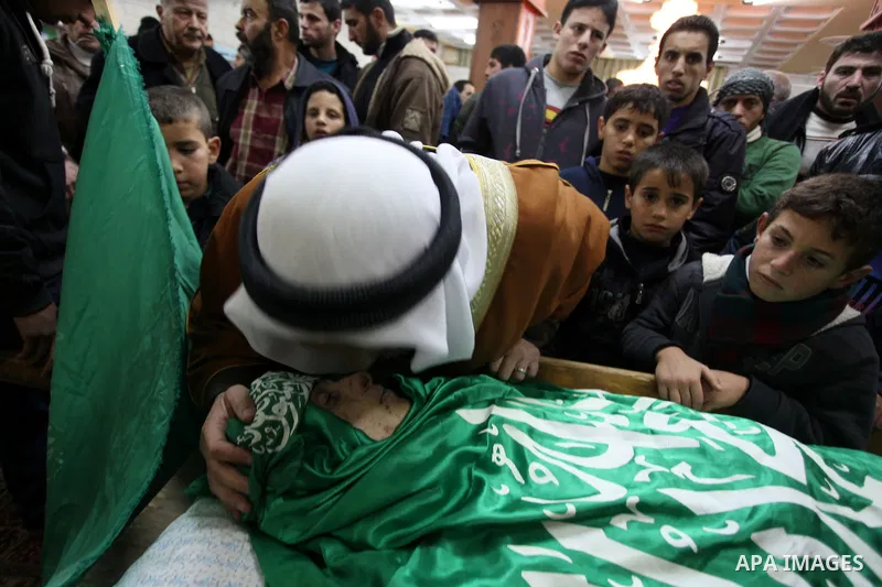 Relatives of Palestinian teenager Mohammed Ziad Salaymeh mourn next to his dead body during the funeral in the West Bank city of Hebron, 13 December 2012. Israeli border police in the divided West Bank city of Hebron on...