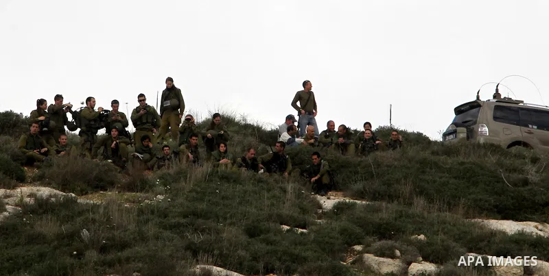 Israeli soldiers walk before clashes broke out with Palestinian protestors during a demonstration against the expropriation of Palestinian land by Israel in the village of Kfar Qaddum, near the occupied West Bank city of...