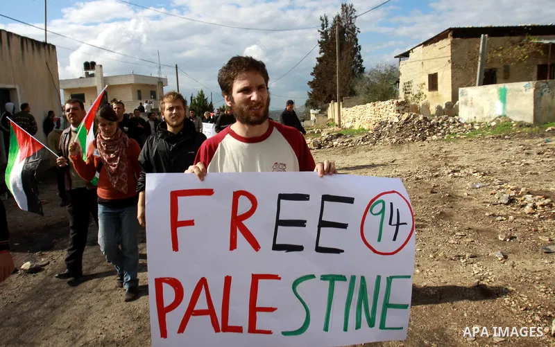 Palestinian protesters hold a placard ''free palestine'' during a demonstration against the expropriation of Palestinian land by Israel in the village of Kfar Qaddum, near the occupied West Bank city of Nablus, on Decemb...