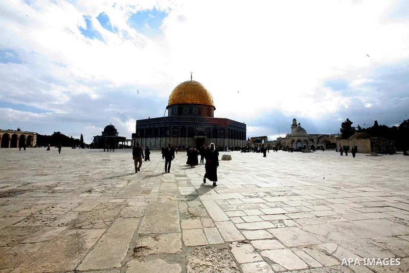 Palestinian and foreign worshippers walk in front of the Dome of the Rock mosque following Friday prayer at al-Aqsa mosque, Islam's third holiest site, on December 14, 2012, in the old city of Jerusalem. Photo by Mahfouz...