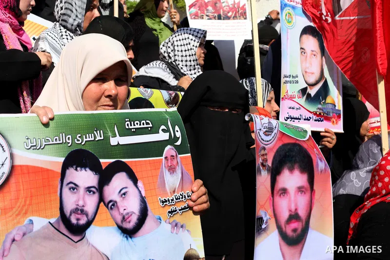 Palestinian women hold flags and portraits of Palestinian prisoners held in Israeli jails during a rally calling for their release, in Gaza city on Dec. 15, 2012. Photo by Ashraf Amra