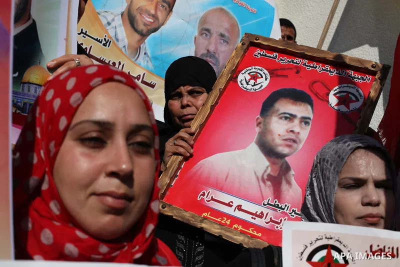 Palestinian women hold flags and portraits of Palestinian prisoners held in Israeli jails during a rally calling for their release, in Gaza city on Dec. 15, 2012. Photo by Ashraf Amra