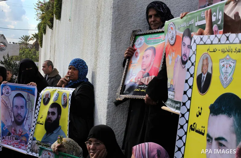 Palestinian women hold flags and portraits of Palestinian prisoners held in Israeli jails during a rally calling for their release, in Gaza city on Dec. 15, 2012. Photo by Ashraf Amra