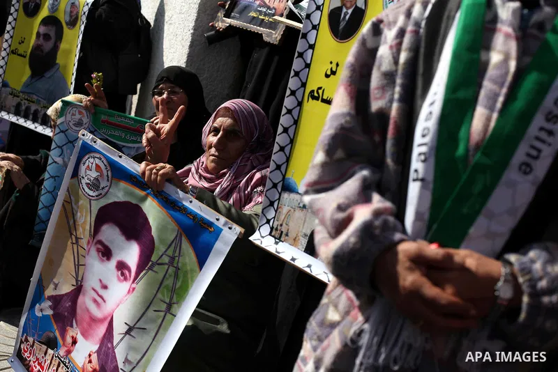 Palestinian women hold flags and portraits of Palestinian prisoners held in Israeli jails during a rally calling for their release, in Gaza city on Dec. 15, 2012. Photo by Ashraf Amra