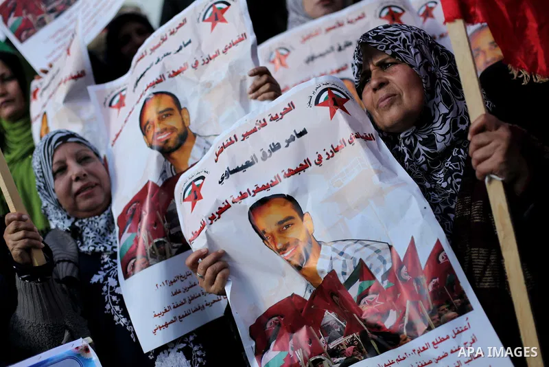 Palestinian women hold flags and portraits of Palestinian prisoners held in Israeli jails during a rally calling for their release, in Gaza city on Dec. 15, 2012. Photo by Ashraf Amra