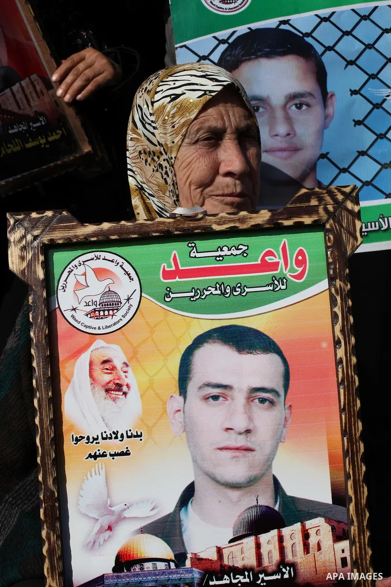 Palestinian women hold flags and portraits of Palestinian prisoners held in Israeli jails during a rally calling for their release, in Gaza city on Dec. 15, 2012. Photo by Ashraf Amra