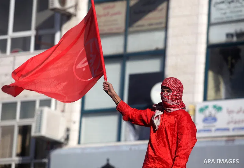 Palestinians wave flags during a rally marking the 45th anniversary of the Popular Front for the Liberation of Palestine (PFLP), in the West Bank city of Ramallah, Saturday, Dec. 15, 2012. Photo by Issam Rimawi