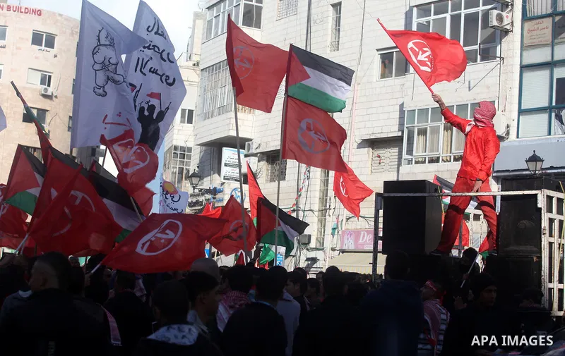Palestinians wave flags during a rally marking the 45th anniversary of the Popular Front for the Liberation of Palestine (PFLP), in the West Bank city of Ramallah, Saturday, Dec. 15, 2012. Photo by Issam Rimawi