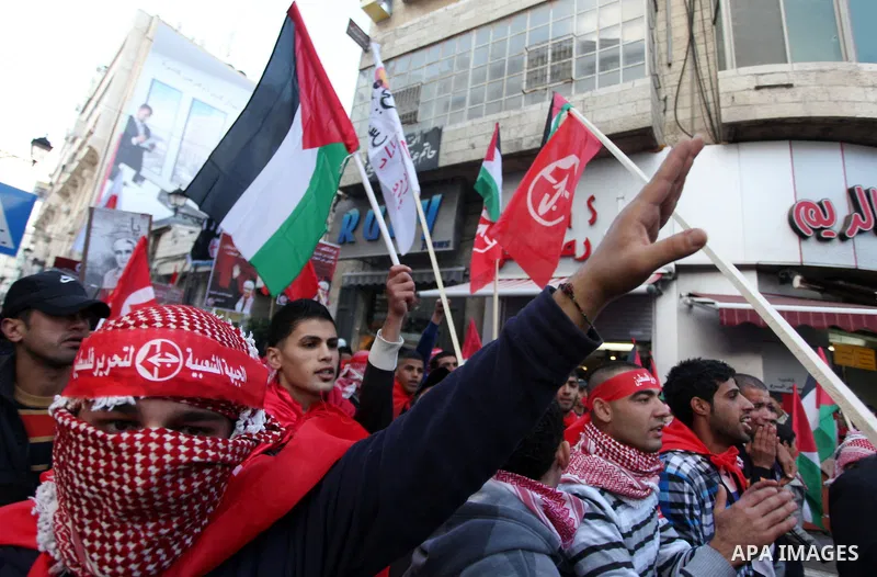 Palestinians wave flags during a rally marking the 45th anniversary of the Popular Front for the Liberation of Palestine (PFLP), in the West Bank city of Ramallah, Saturday, Dec. 15, 2012. Photo by Issam Rimawi