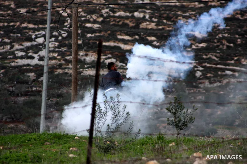 A Palestinian protester runs from tear gas after an attack by Israeli settlers on Palestinian homes in village of Urif near the west bank city of Nablus on Dec. 15, 2012 . Photo by Nedal Eshtayah
