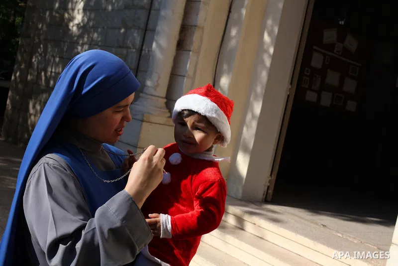 A Palestinian child dressed as Pope Claus during visiting Latin Patriarch of Jerusalem Fouad Twal in Gaza City, Sunday, Dec. 16, 2012. Twal arrived in Gaza on Sunday to attend a celebration with Palestinians ahead of Chr...