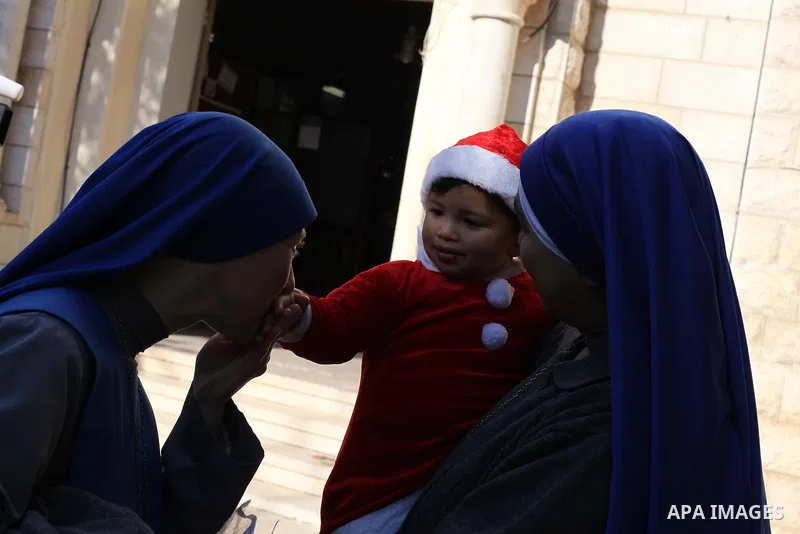 A Palestinian child dressed as Pope Claus during visiting Latin Patriarch of Jerusalem Fouad Twal in Gaza City, Sunday, Dec. 16, 2012. Twal arrived in Gaza on Sunday to attend a celebration with Palestinians ahead of Chr...