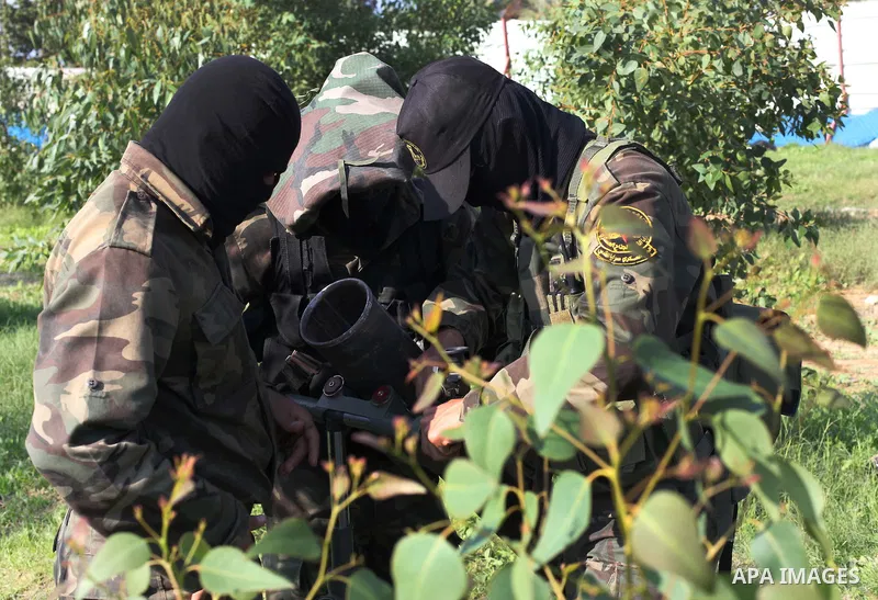 Palestinian militants from al-Quds Brigades the armed wing of the Islamic Jihad organization, stand around a rocket launcher during military exercises at an undisclosed location in the Hamas-run Gaza Strip in Gaza city o...