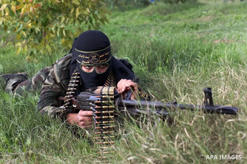 A Palestinian militant from al-Quds Brigades the armed wing of the Islamic Jihad organization, lies down during military exercises at an undisclosed location in the Hamas-run Gaza Strip in Gaza city on Dec 16. 2012. Hama...