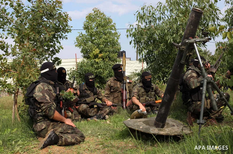 Palestinian militants from al-Quds Brigades the armed wing of the Islamic Jihad organization, sit around a rocket launcher during military exercises at an undisclosed location in the Hamas-run Gaza Strip in Gaza city on...