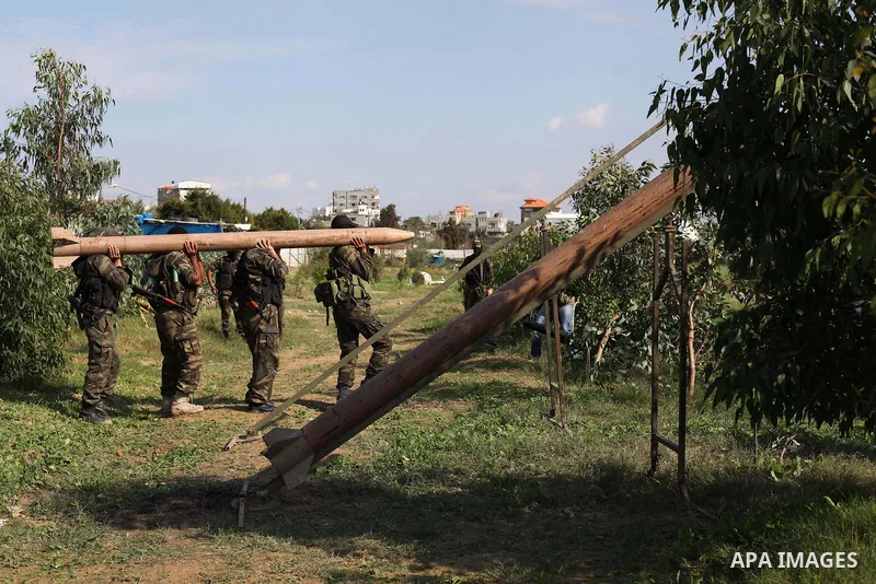 Palestinian militants from al-Quds Brigades the armed wing of the Islamic Jihad organization, stand around a rocket launcher during military exercises at an undisclosed location in the Hamas-run Gaza Strip in Gaza city o...
