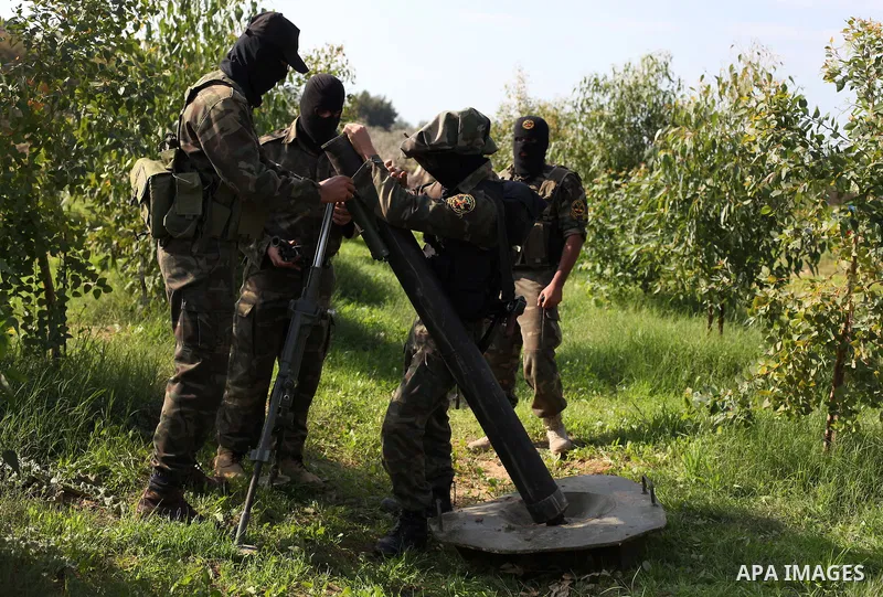 Palestinian militants from al-Quds Brigades the armed wing of the Islamic Jihad organization, stand around a rocket launcher during military exercises at an undisclosed location in the Hamas-run Gaza Strip in Gaza city o...