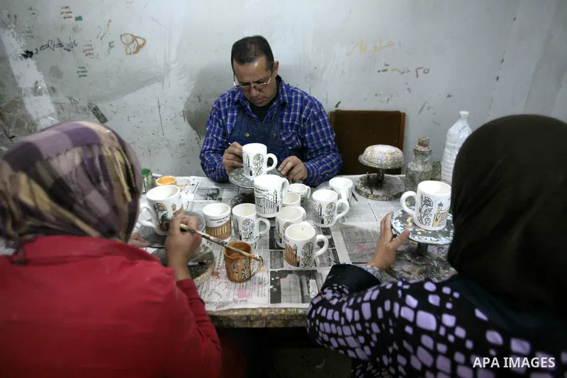 Palestinian workesr paint on a ceramic cup by using traditional skills in the West Bank city of Hebron on 16 December, 2012. Palestinian ceramics are produced at traditional family-owned factories in Hebron and other cit...