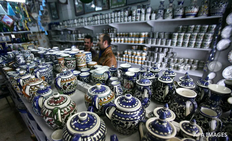 Palestinian look at handicraft ceramic utensils in the West Bank city of Hebron on 16 December, 2012. Palestinian ceramics are produced at traditional family-owned factories in Hebron and other cities. Covering a wide ra...