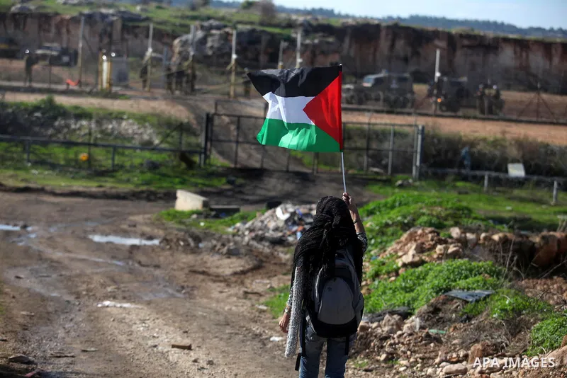 A Palestinian activist holds national flag as she demonstrate in front of Israeli soldiers against the destruction of a monument commemorating the death of Egyptian soldiers killed during the 1967 Six-Day war in the West...