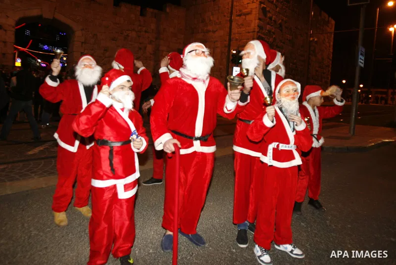 Palestinians dressed up as Santa Claus take part in a parade ahead of Christmas near Jerusalem's Old City December 16, 2012. Photo by Mahfouz Abu Turk