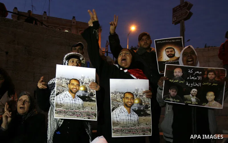 Palestinian protesters hold portraits of Samer Issawi, a Palestinian prisoner held in an Israeli jail and on a hunger strike since August 1, during a demonstration marking his birthday outside Damascus gate, in the old c...