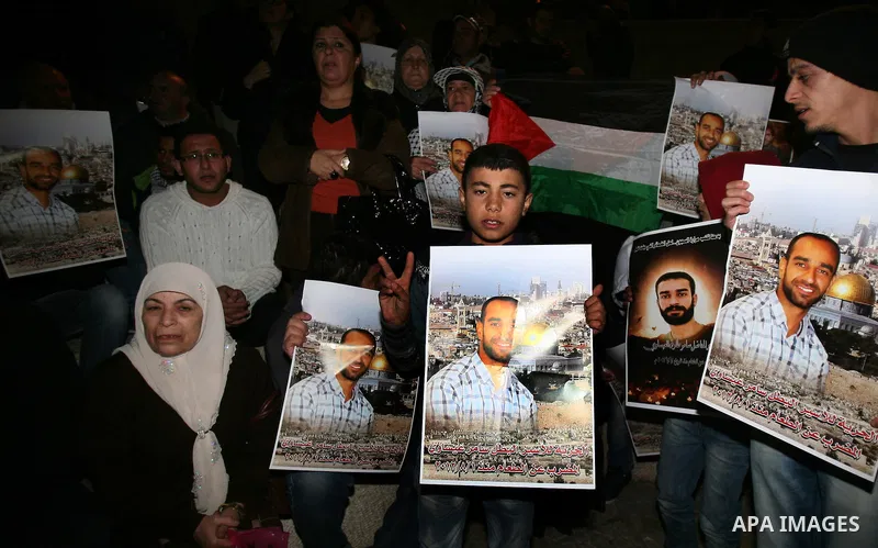 Palestinian protesters hold portraits of Samer Issawi, a Palestinian prisoner held in an Israeli jail and on a hunger strike since August 1, during a demonstration marking his birthday outside Damascus gate, in the old c...