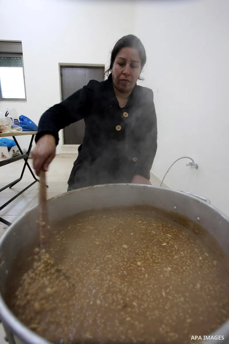 A Palestinian woman makes traditional sweets to mark the annual festival of St. Barbara's Day in the Palestinian village of Abud, in the Israeli occupied West Bank on December 16, 2012. Photo by Issam Rimawi