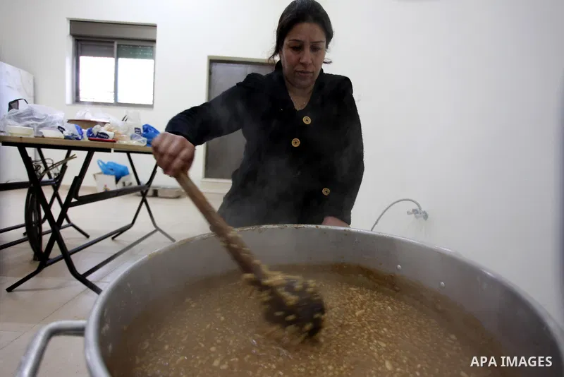 A Palestinian woman makes traditional sweets to mark the annual festival of St. Barbara's Day in the Palestinian village of Abud, in the Israeli occupied West Bank on December 16, 2012. Photo by Issam Rimawi