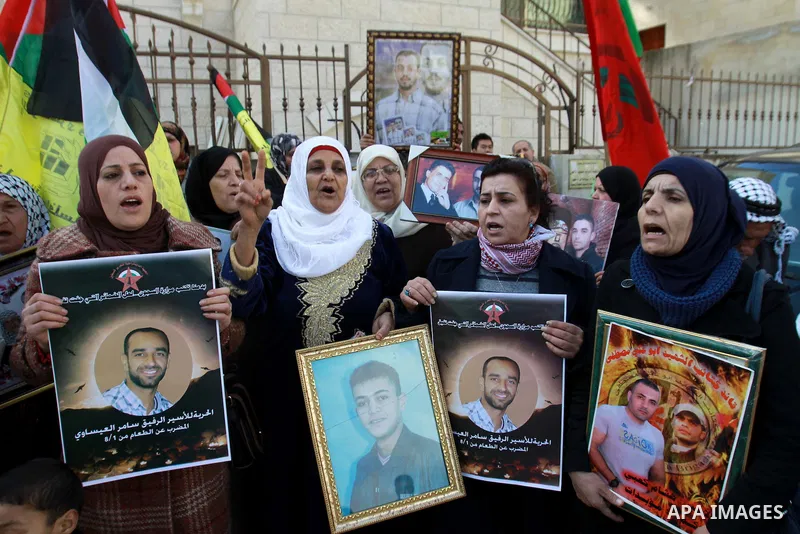 Palestinians hold pictures of their prisoner relatives in Israeli jails as they gather in a weekly activity calling for their liberty at the Red Cross headquarters in the West Bank city of Nablus on December 17, 2012. Ph...