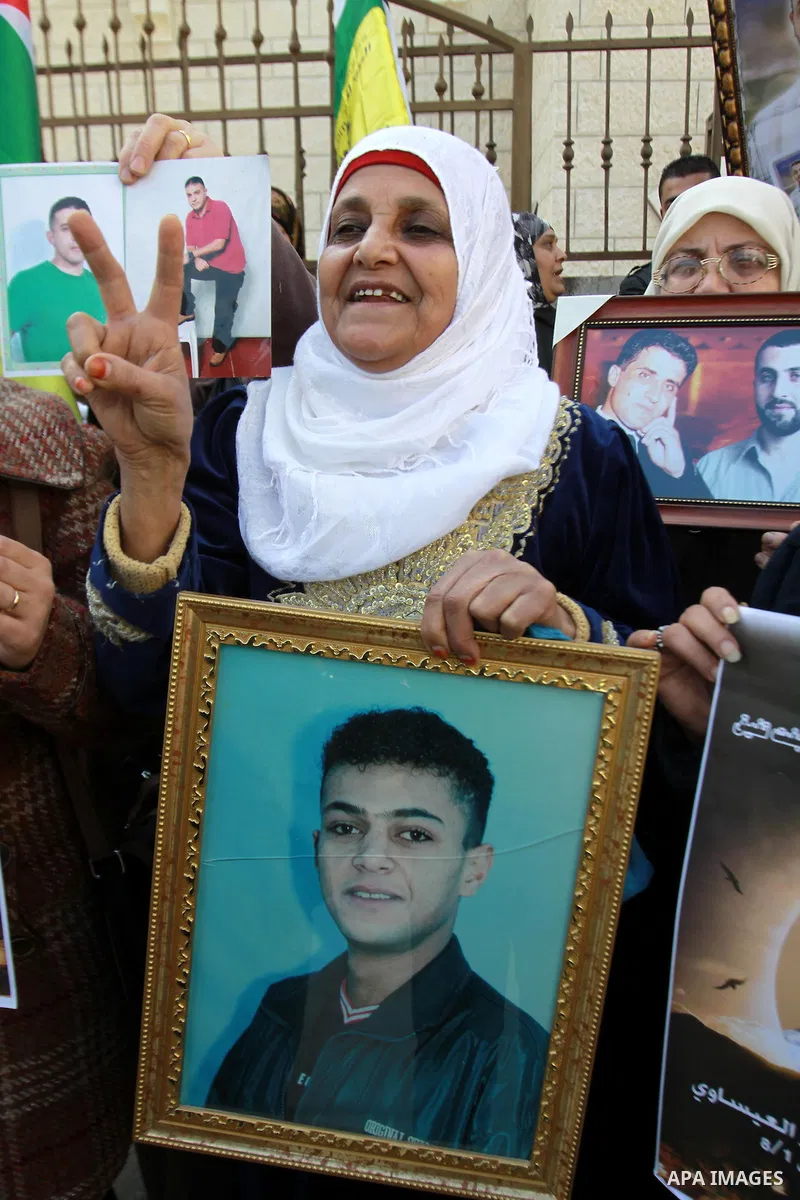Palestinians hold pictures of their prisoner relatives in Israeli jails as they gather in a weekly activity calling for their liberty at the Red Cross headquarters in the West Bank city of Nablus on December 17, 2012. Ph...
