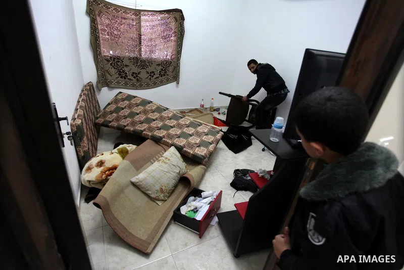 Palestinians look at ransacked belongings after Israeli soldiers entered the house and arrested three brothers and another Palestinian, who was wounded, in the northern West Bank village of Beit Rima, near Ramallah on De...