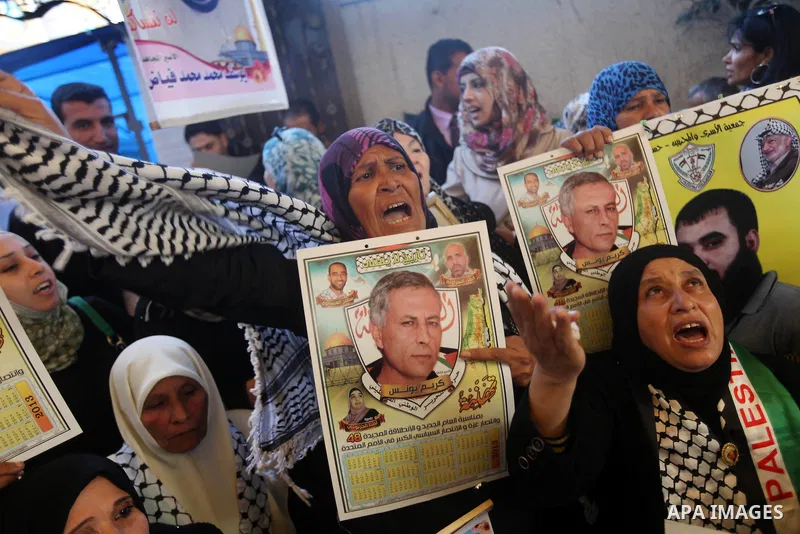 Palestinians hold pictures of their prisoner relatives in Israeli jails as they gather in a weekly activity calling for their liberty at the Red Cross headquarters in Gaza city on December 17, 2012. Photo by Majdi Fathi