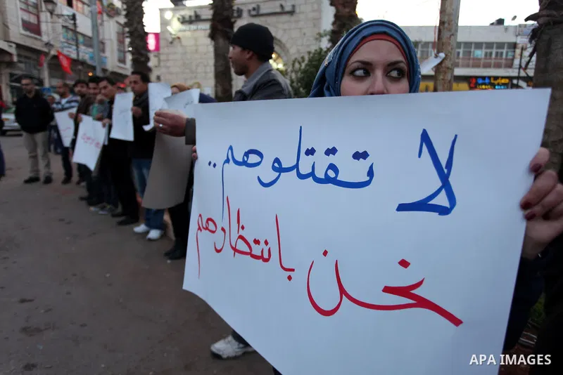 Palestinians hold placards during a protest in solidarity with Palestinian in al-Yarmouk refugee camp in Syria in the West Bank city of Ramallah on 17 December 2012. Pro-rebel sources reported that at least 25 Palestinia...