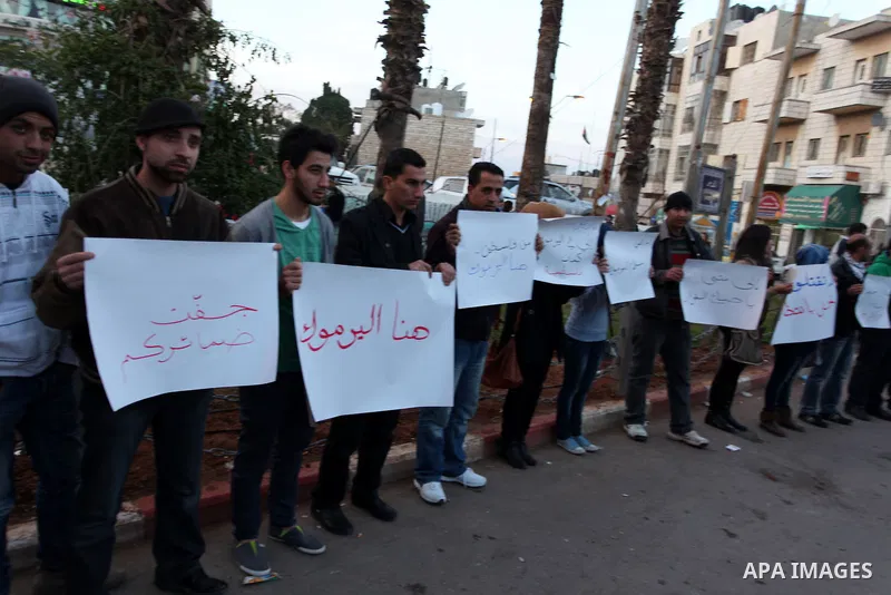Palestinians hold placards during a protest in solidarity with Palestinian in al-Yarmouk refugee camp in Syria in the West Bank city of Ramallah on 17 December 2012. Pro-rebel sources reported that at least 25 Palestinia...
