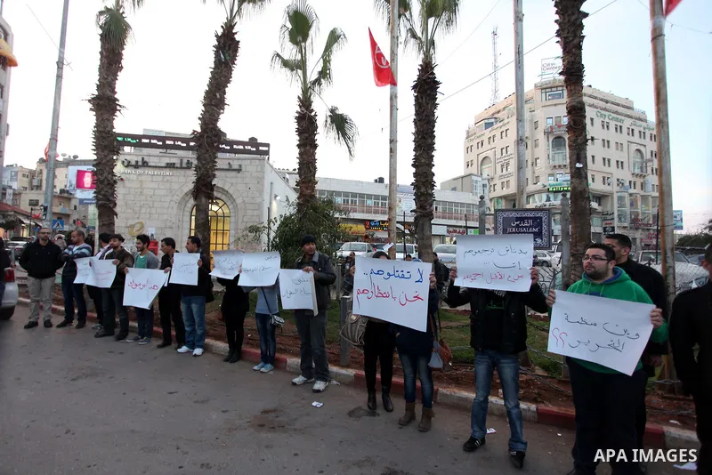 Palestinians hold placards during a protest in solidarity with Palestinian in al-Yarmouk refugee camp in Syria in the West Bank city of Ramallah on 17 December 2012. Pro-rebel sources reported that at least 25 Palestinia...