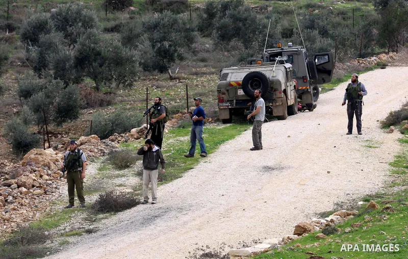 Israeli soldiers stand as Jewish settlers hurl stones during clashes with Palestinians, not seen, outside the West Bank village of Madama and the Jewish settlement of Yitzhar, near Nablus, Dec. 17, 2012. Photo by Nedal E...