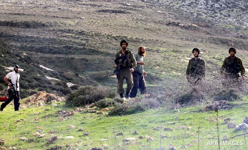 Israeli soldiers stand as Jewish settlers hurl stones during clashes with Palestinians, not seen, outside the West Bank village of Madama and the Jewish settlement of Yitzhar, near Nablus, Dec. 17, 2012. Photo by Nedal E...