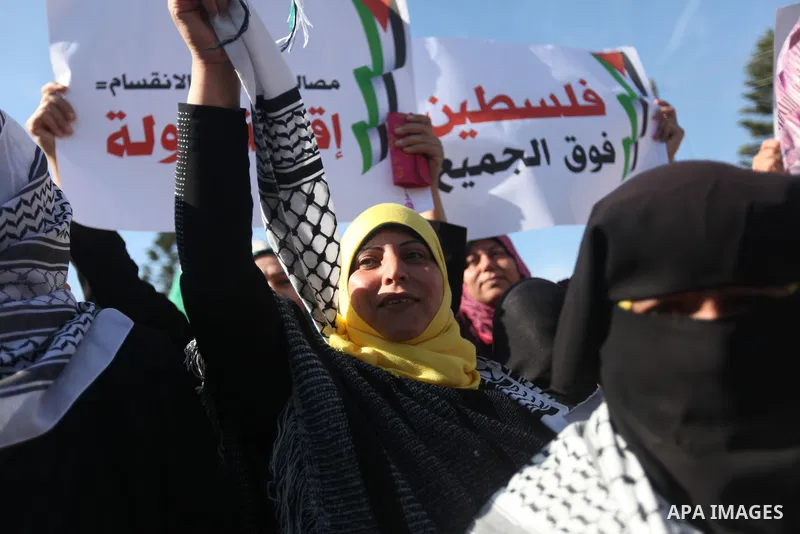 Palestinian women chant slogans during a protest calling for unity and to end the internal Palestinian division in Gaza City, Tuesday, Dec. 18, 2012. Arabic on the poster, left, reads," Palestine is above all," and at ri...