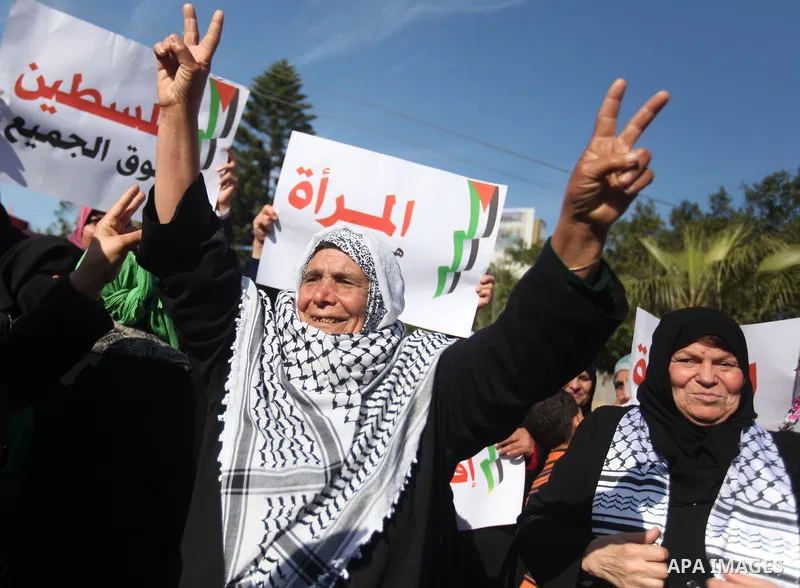 Palestinian women chant slogans during a protest calling for unity and to end the internal Palestinian division in Gaza City, Tuesday, Dec. 18, 2012. Arabic on the poster, left, reads," Palestine is above all," and at ri...