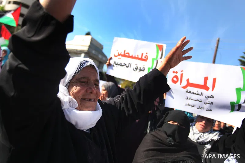 Palestinian women chant slogans during a protest calling for unity and to end the internal Palestinian division in Gaza City, Tuesday, Dec. 18, 2012. Arabic on the poster, left, reads," Palestine is above all," and at ri...