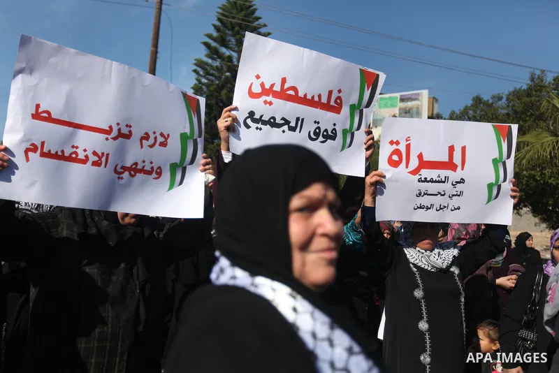 Palestinian women chant slogans during a protest calling for unity and to end the internal Palestinian division in Gaza City, Tuesday, Dec. 18, 2012. Arabic on the poster, left, reads," Palestine is above all," and at ri...