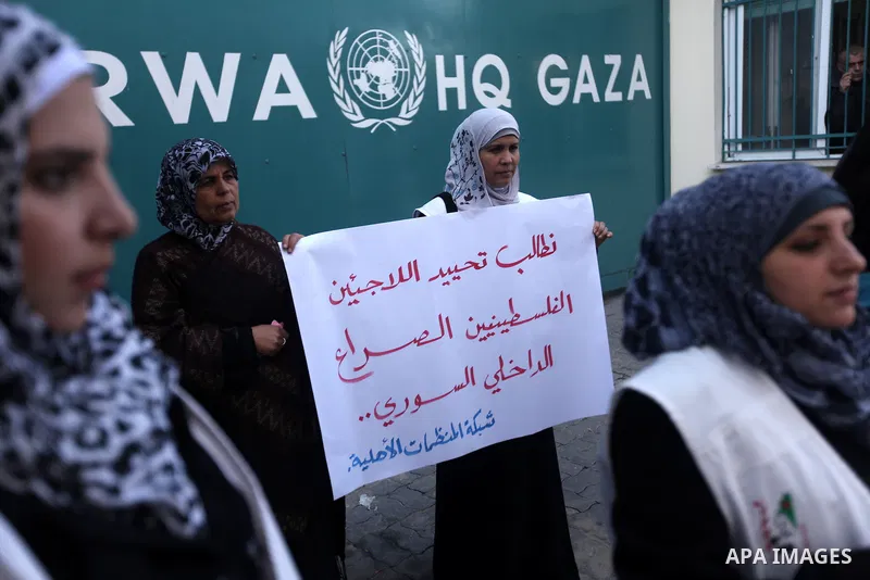 Palestinians hold placards during a protest in solidarity with Palestinian in al-Yarmouk refugee camp in Syria in In front of the United Nations headquarters in Gaza City on 18 December 2012. Pro-rebel sources reported t...